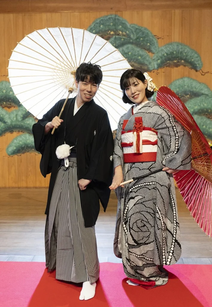 神和苑の能楽堂ステージで撮影した、和装姿の新郎新婦の笑顔あふれる和気あいあいとしたポーズカット
